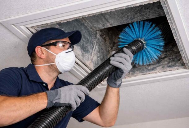 HVAC technician cleaning air duct